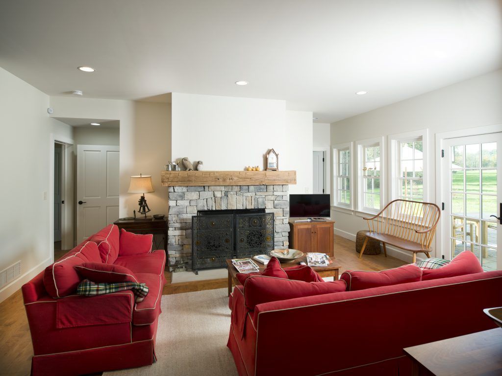 A living room with red furniture and a fireplace.