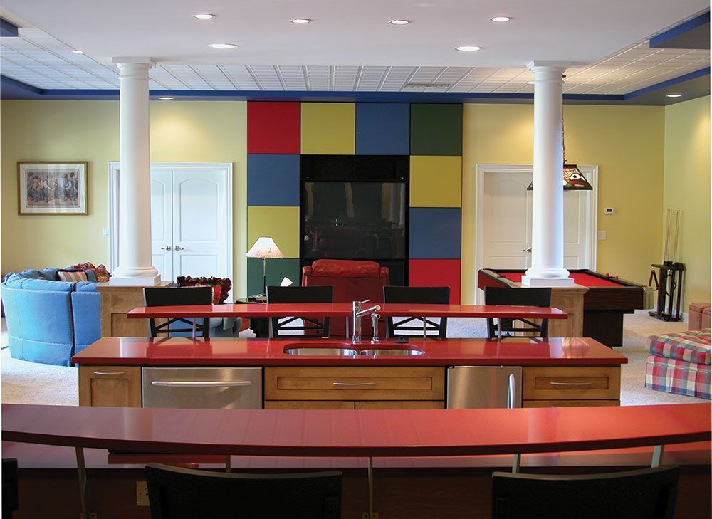 A kitchen with a red counter top and a pool table.
