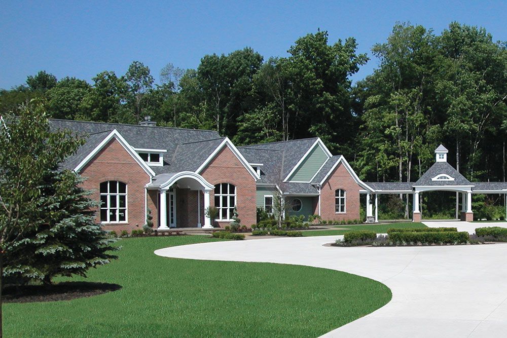 A large brick house with a driveway in front of it.