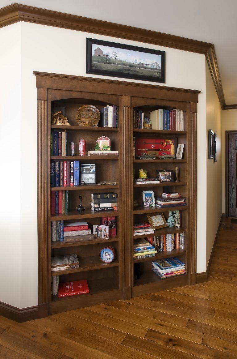 A bookcase with a picture on top of it.