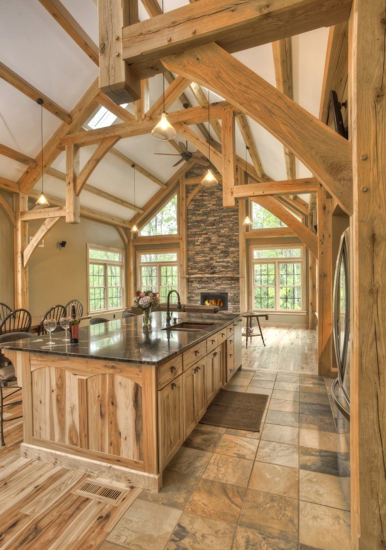 A kitchen with wooden cabinets and a stone fireplace.