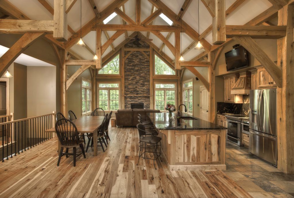 A large wooden house with hardwood floors, dining room table, and chairs and a kitchen.