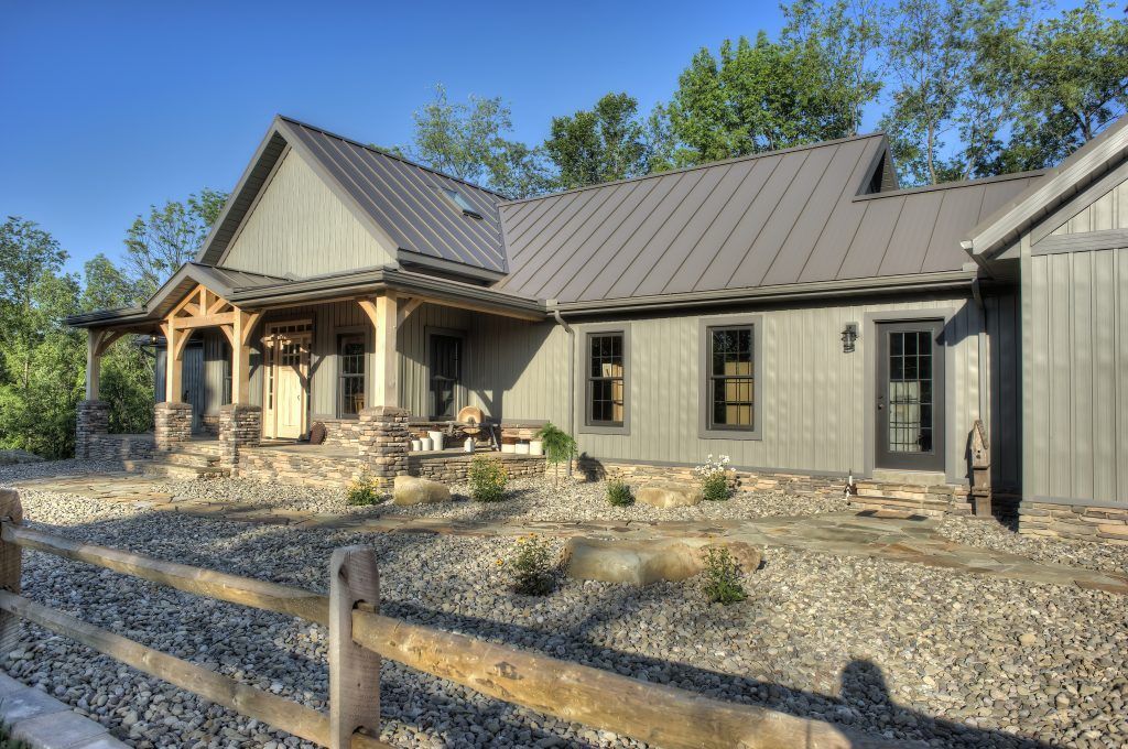 A large house with a metal roof and a wooden fence in front of it.