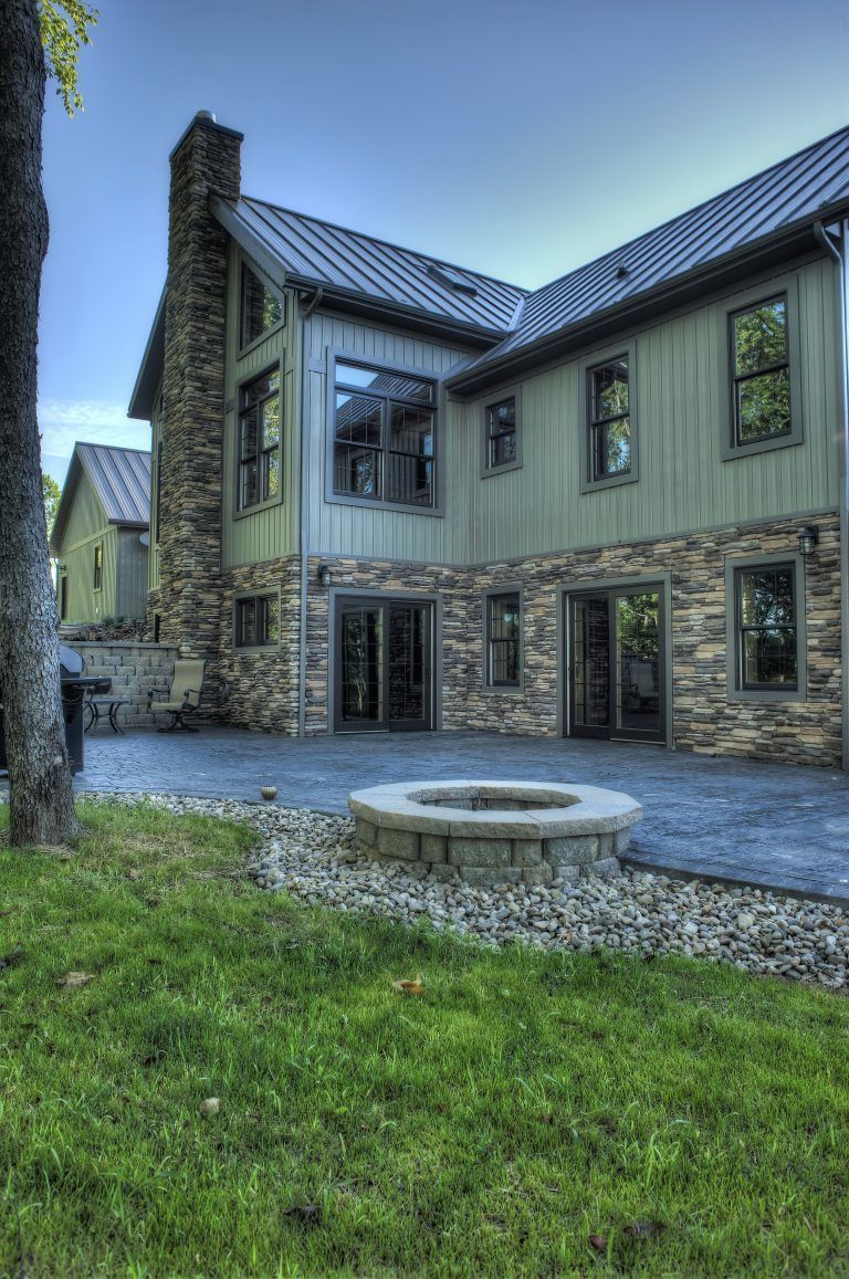 A large house with a fire pit in front of it.