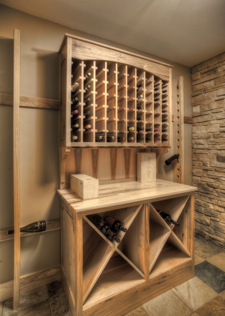 A wooden wine rack in a room with a brick wall.