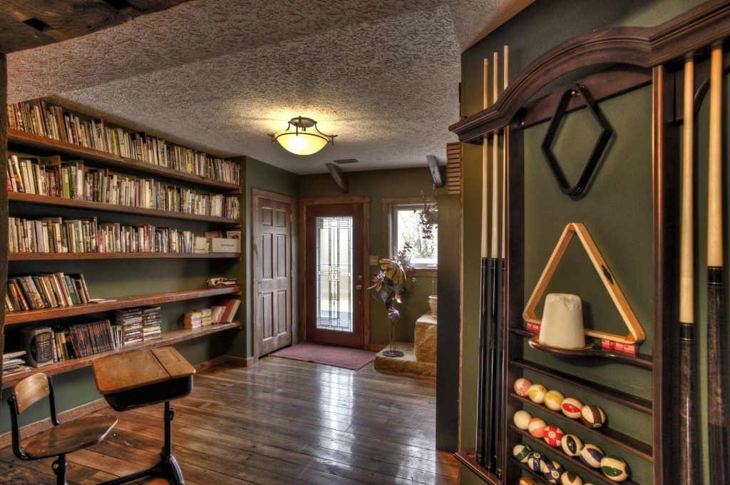 A room with a pool table and a triangle on the wall.