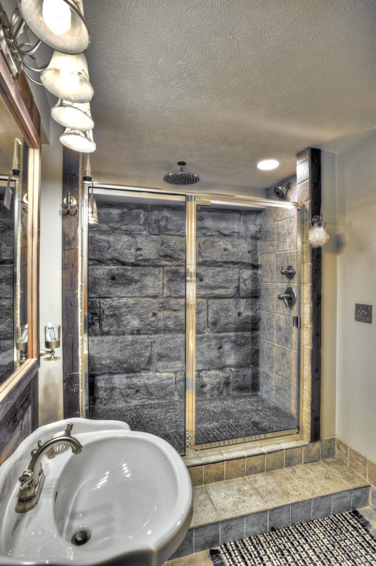 A bathroom with a sink and a walk in shower.