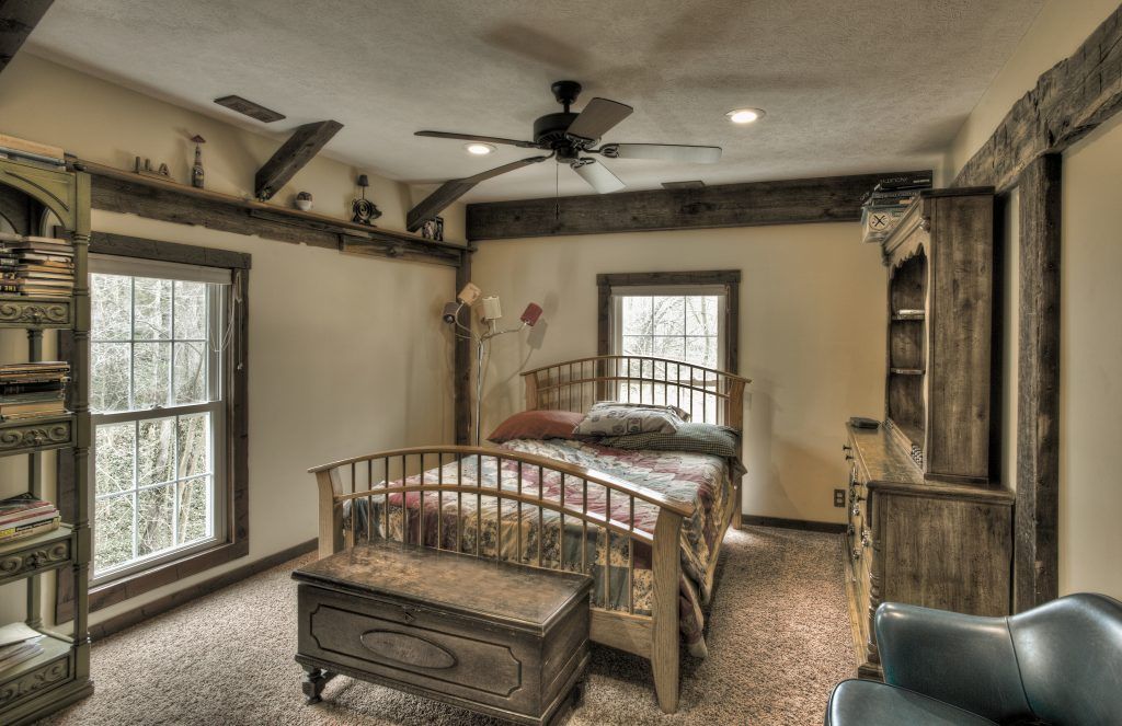A bedroom with a bed and a ceiling fan.