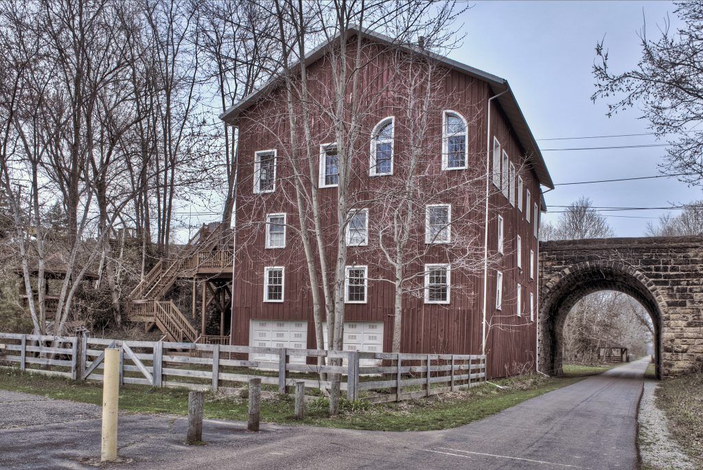 A large red barn with a bridge in the background.