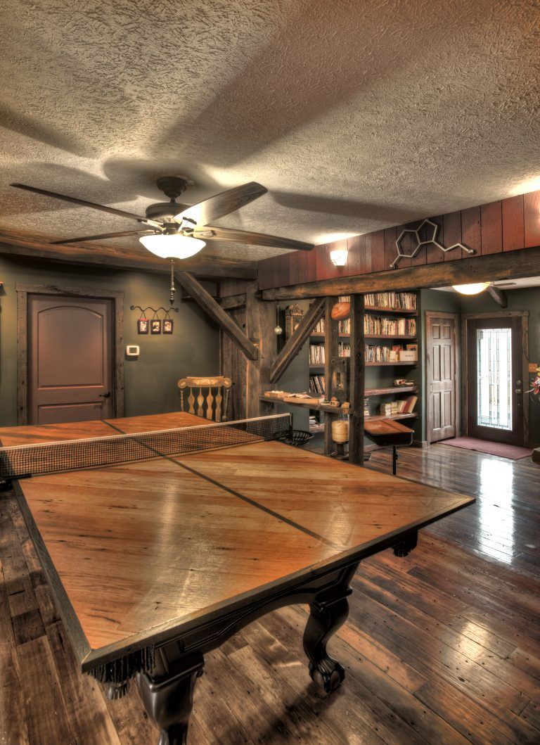A room with a pool table and a ceiling fan.