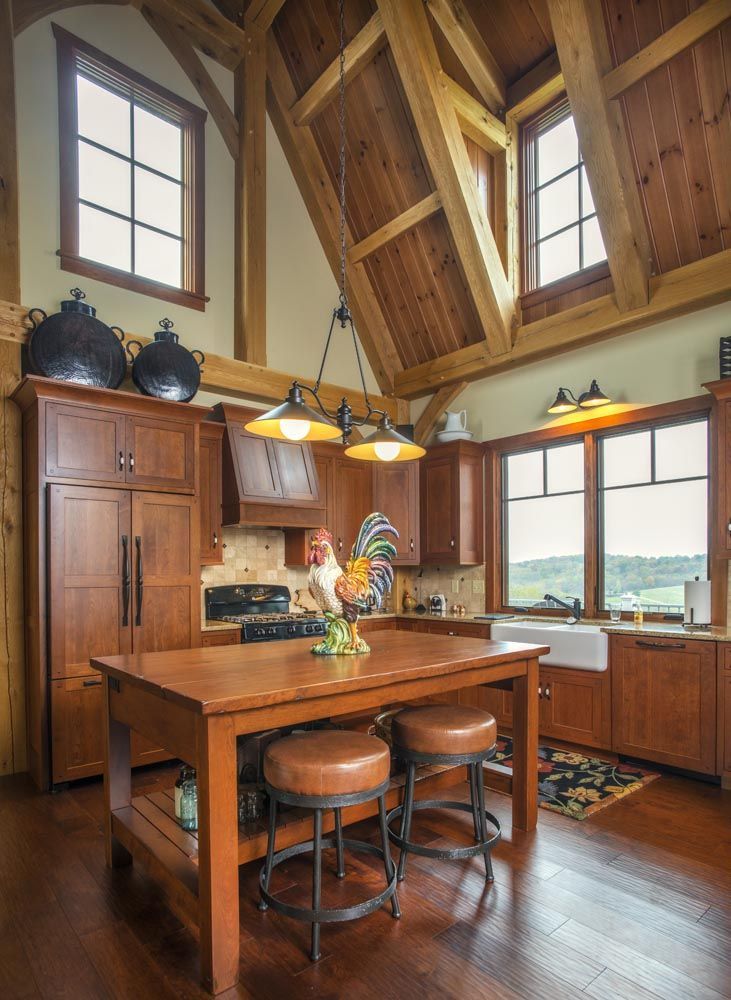 A kitchen with wooden cabinets and a large island in the middle.