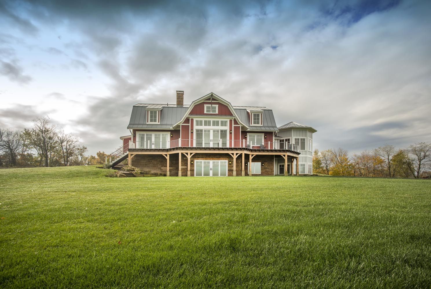A large house is sitting on top of a lush green hill.