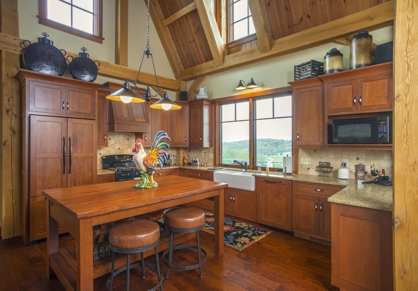 A kitchen with wooden cabinets,, granite counter tops, and table with stools.