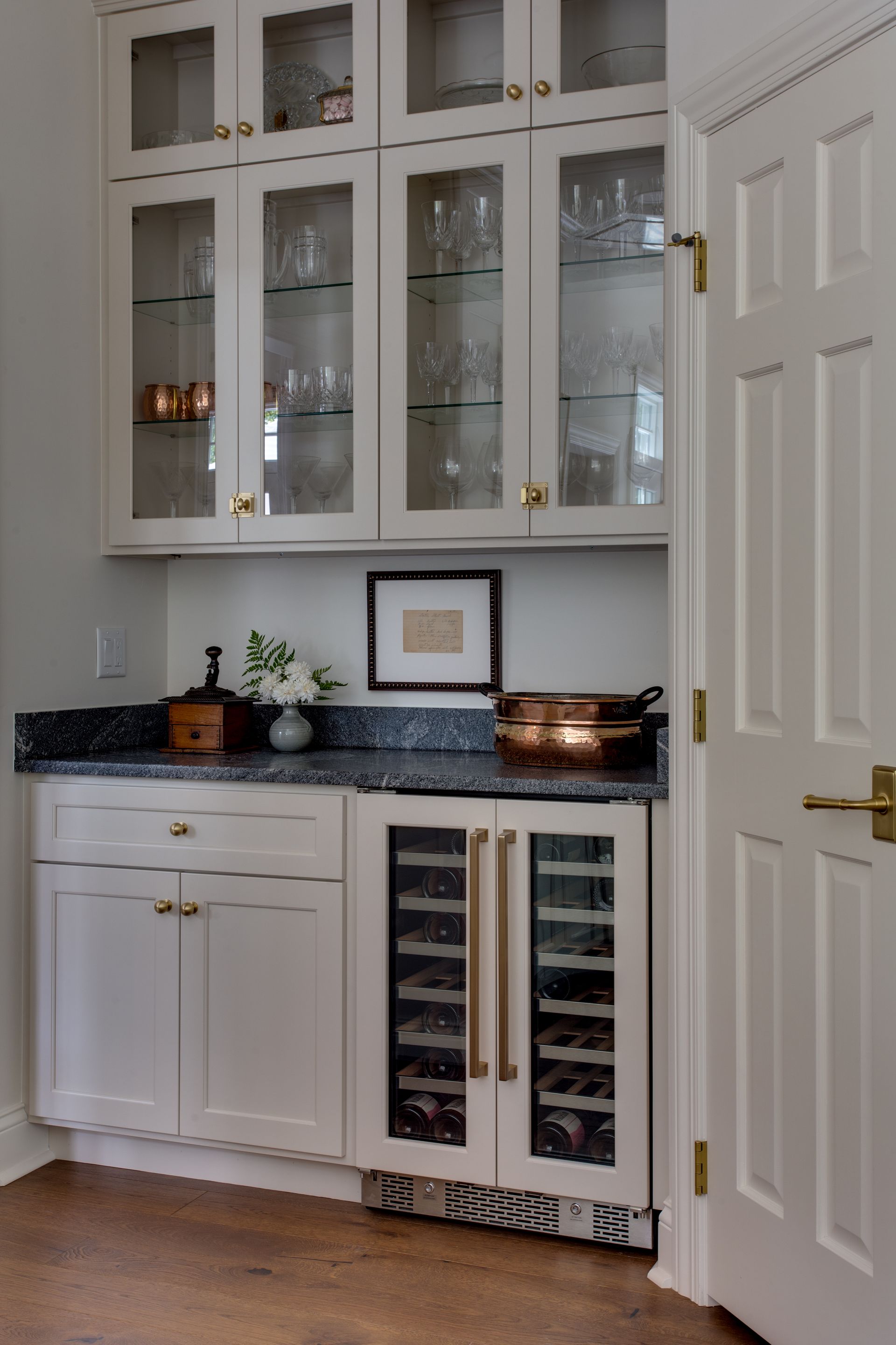A kitchen with white cabinets and a wine cooler.