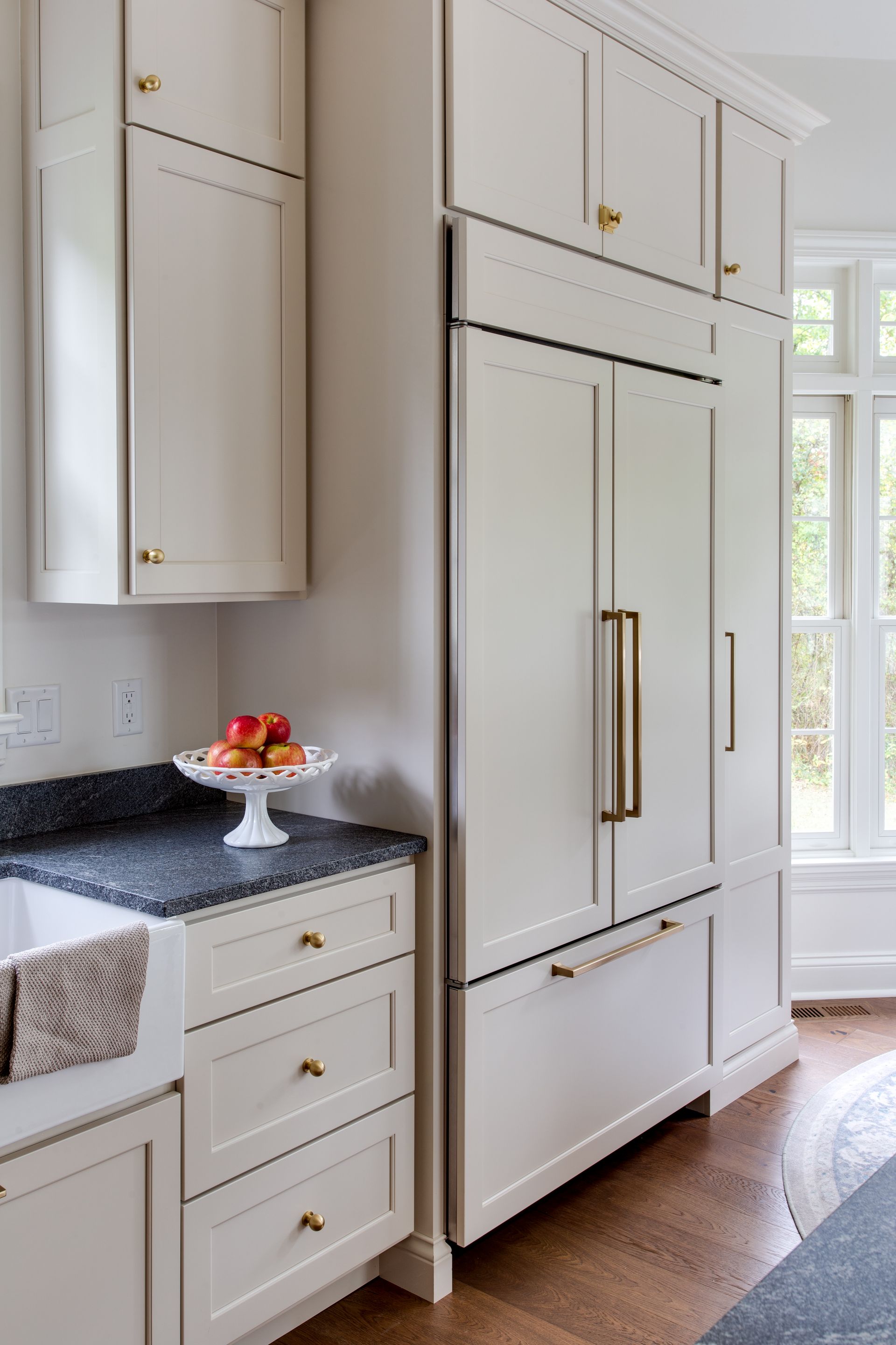 A kitchen with white cabinets , a sink , and a refrigerator.