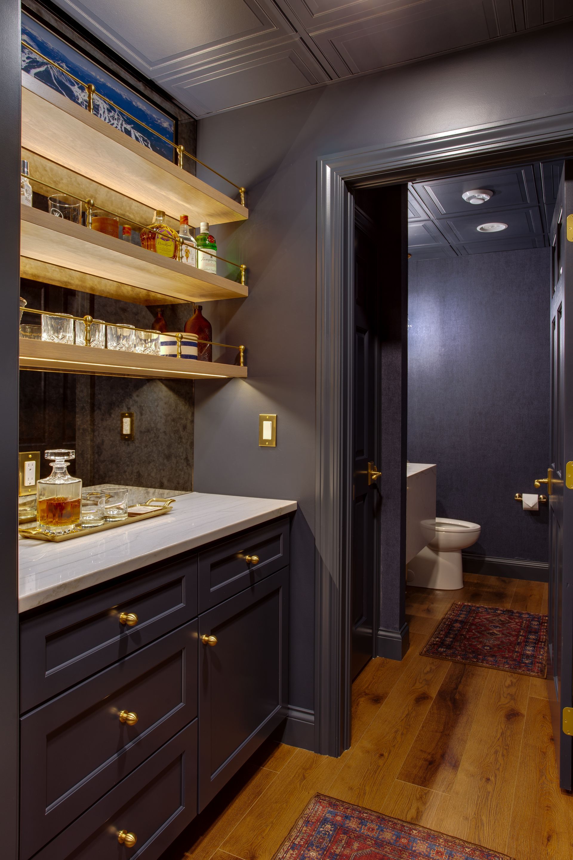 A bathroom with a toilet, sink, and shelves.