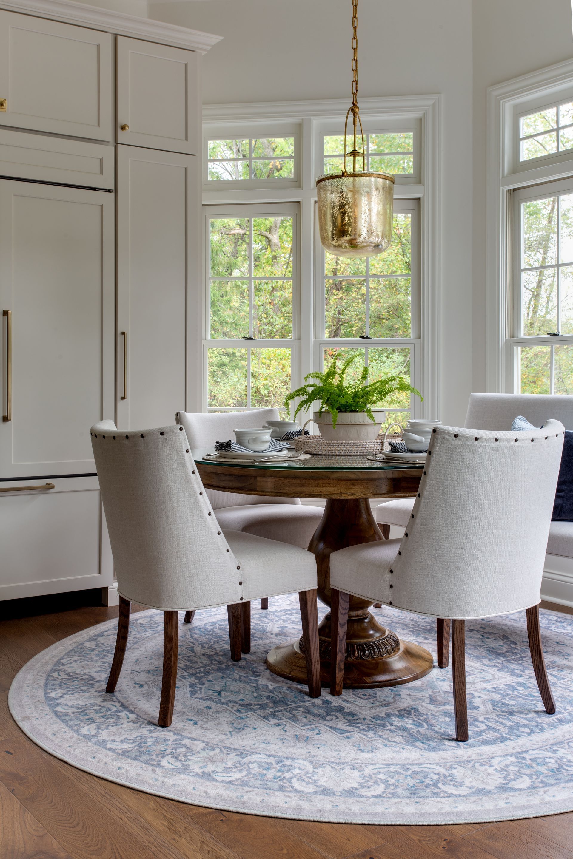 A dining room with a table and chairs and a rug.