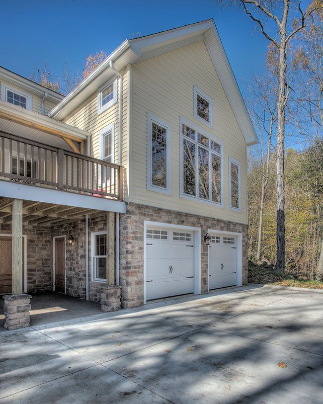 A large house with two garage doors and a deck