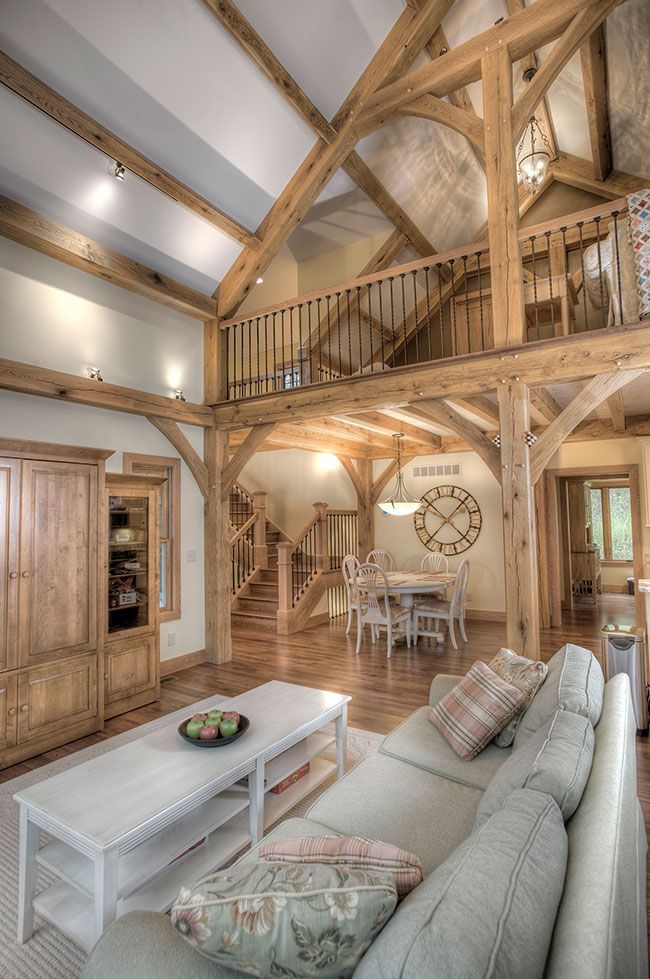 A living room with a couch and a coffee table in a house with wooden beams.