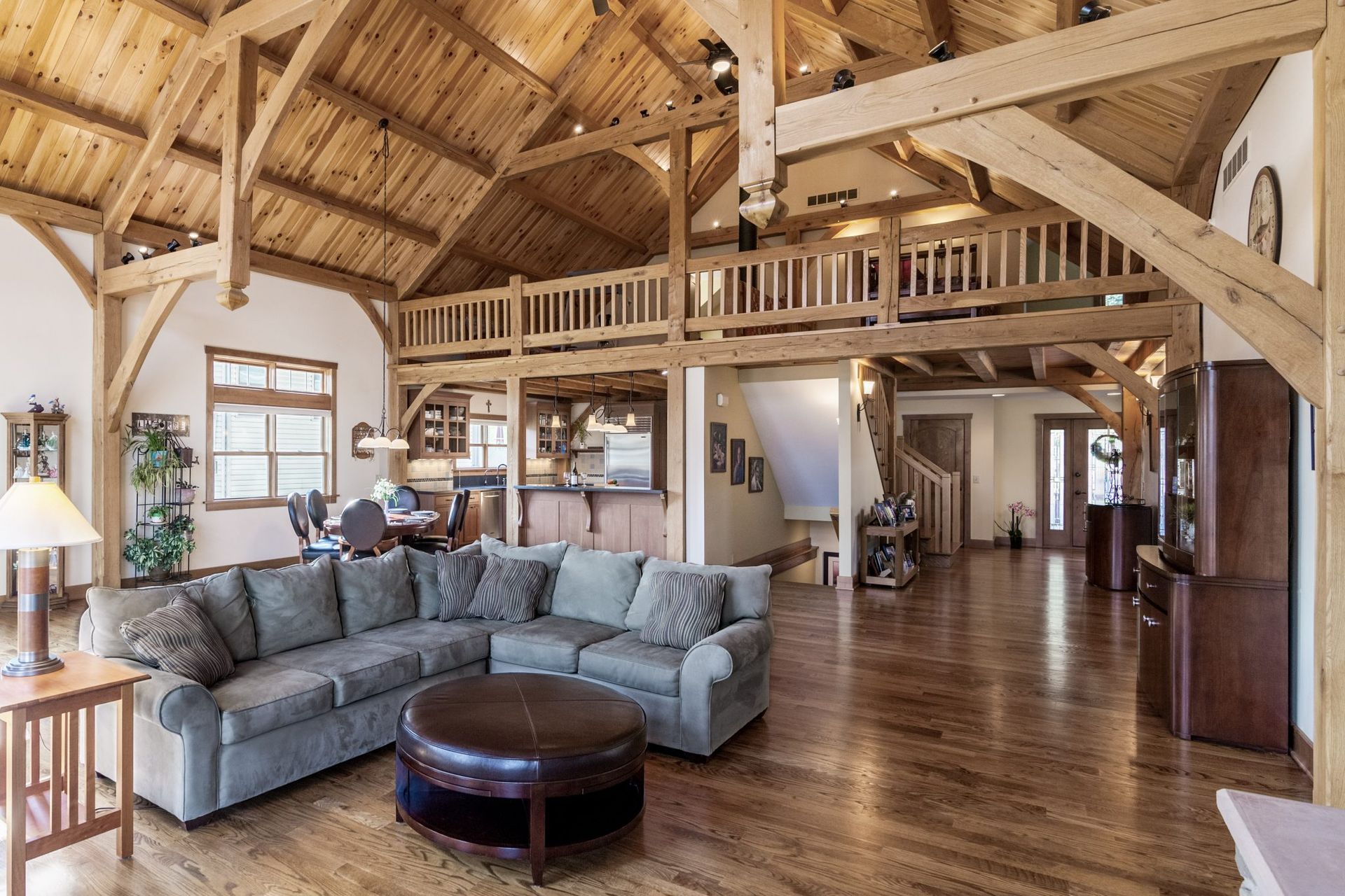 A living room with a large sectional couch and a round coffee table.