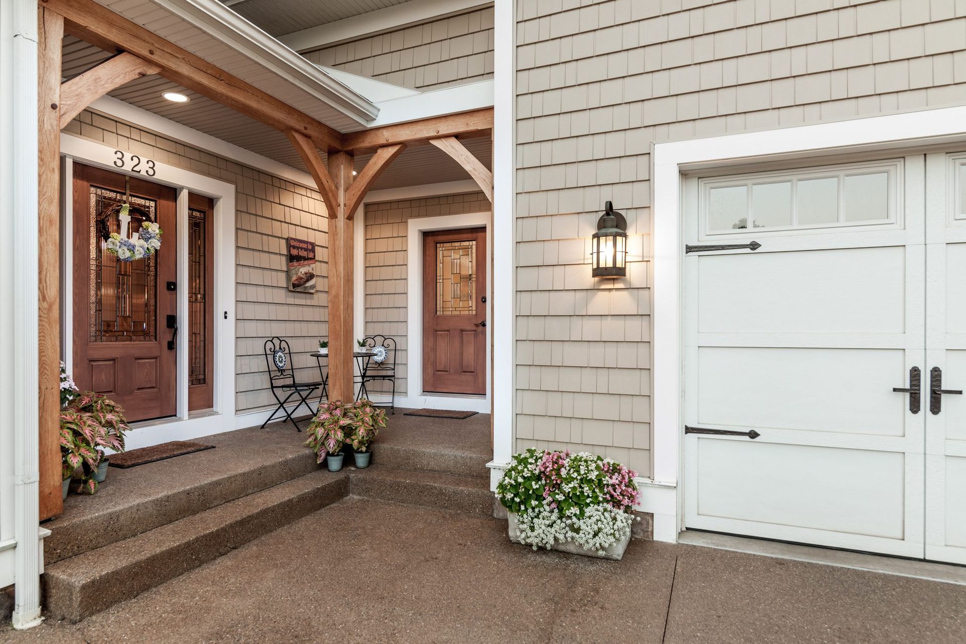 The front of a house with a porch and a garage door.