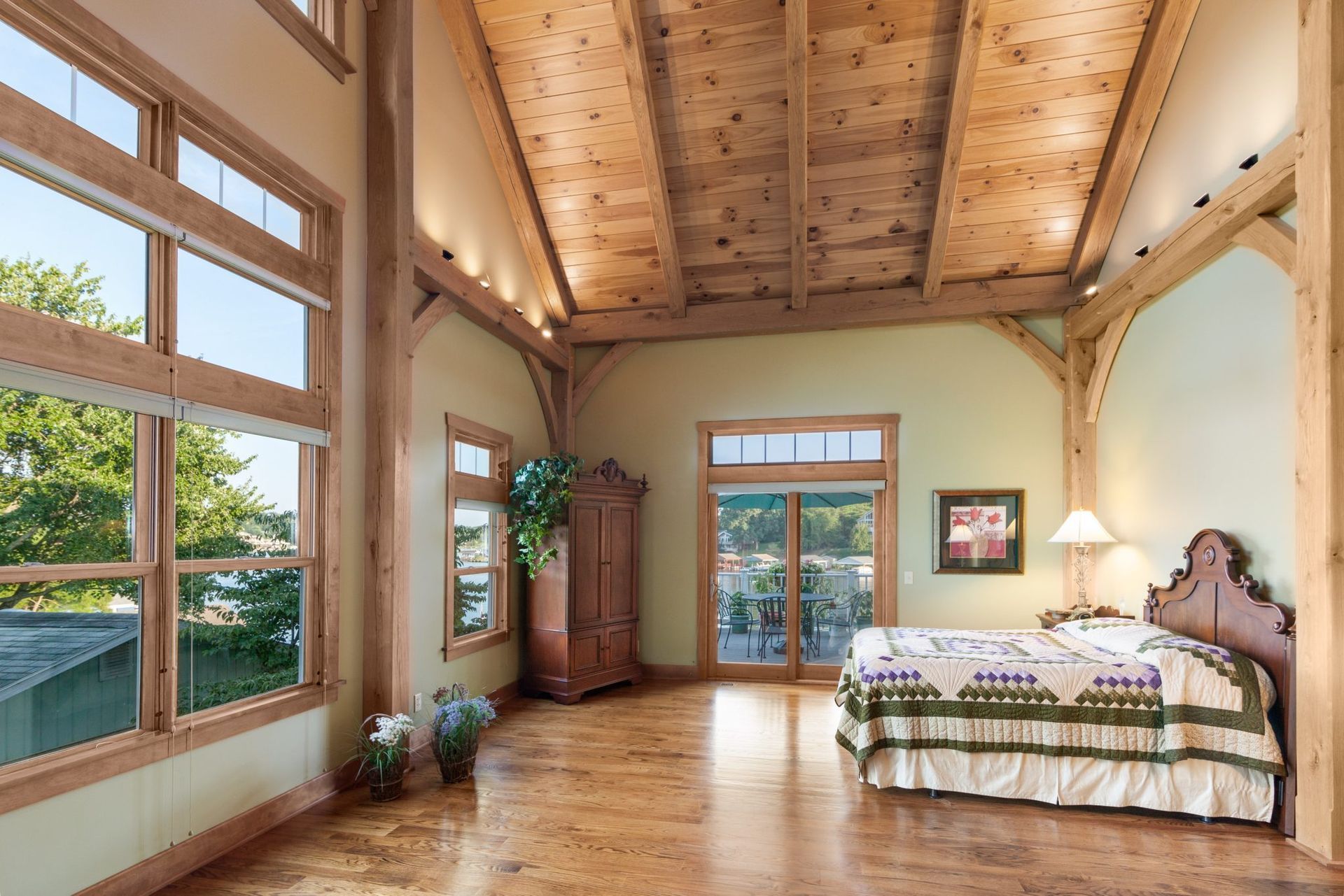 A bedroom with a large bed and lots of windows.