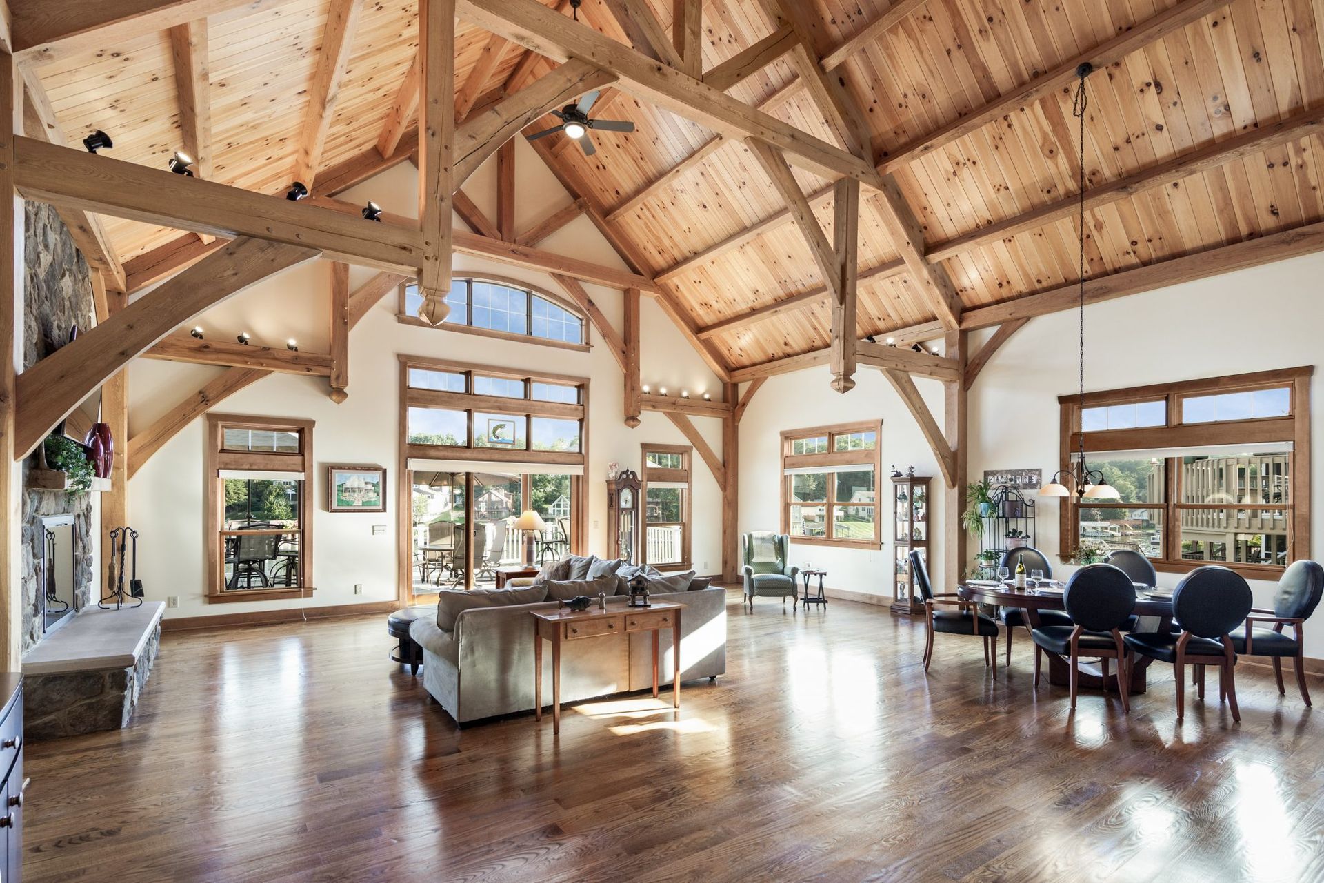 A large room in a beautiful home with a wooden ceiling and lots of windows.