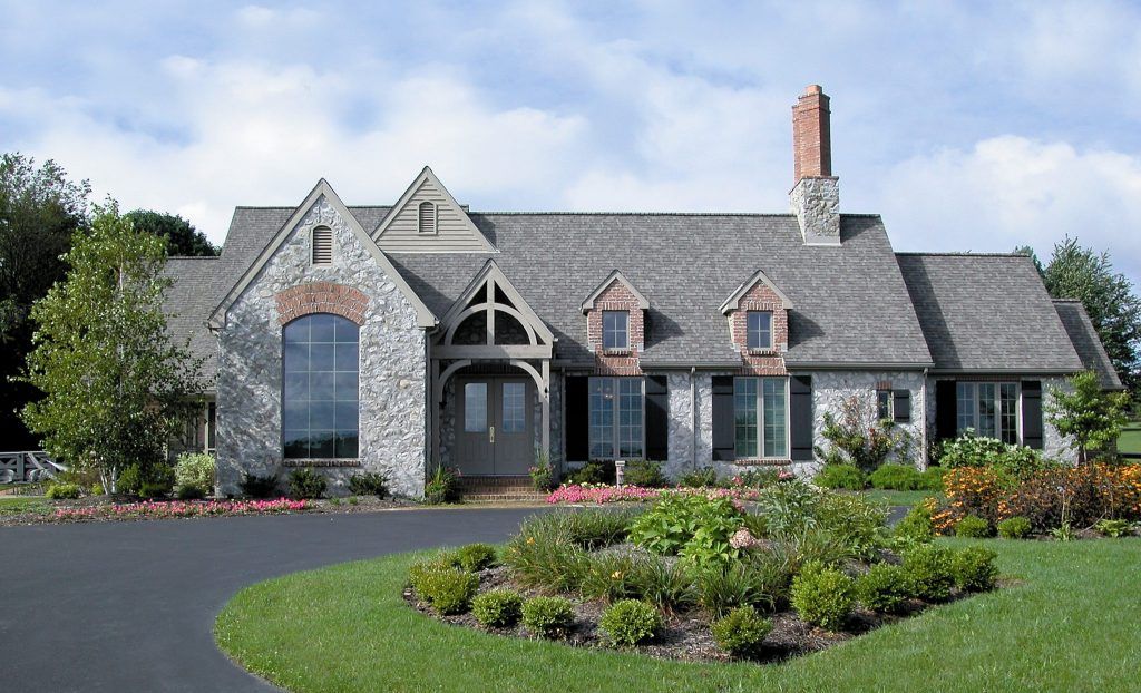 A large house with a gray roof and a chimney.
