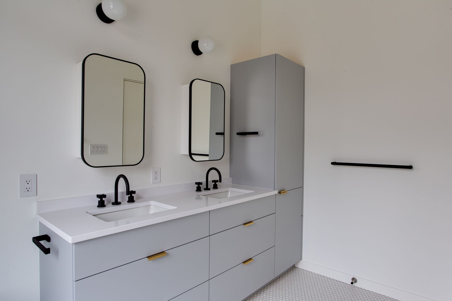 Modern bathroom vanity with two sinks, mirrors, white cabinetry, and a gray shower wall