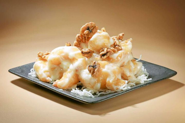 Plate of golden fried dumplings on a white dish, with chopsticks lifting one above it.