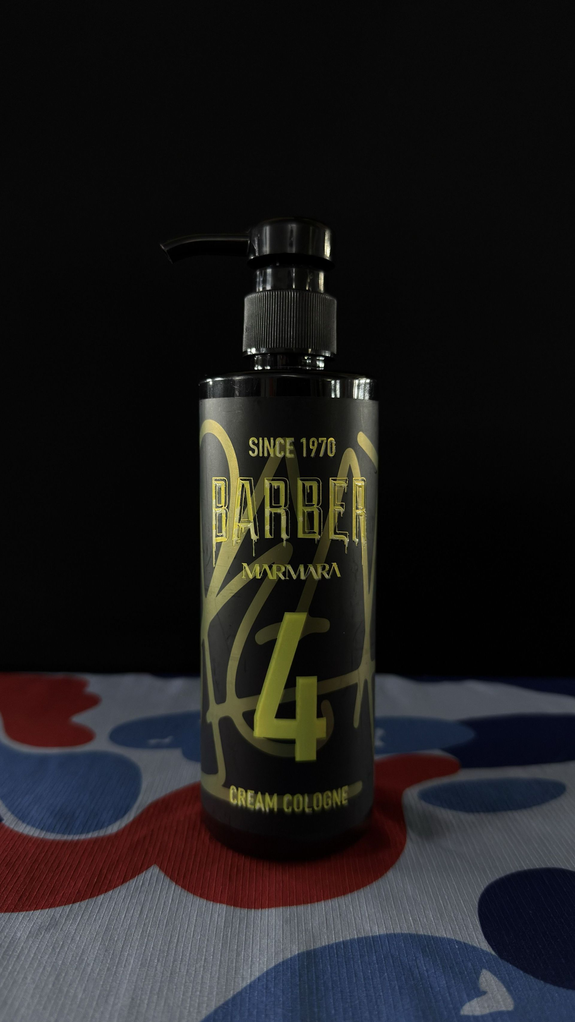A bottle of Barber Marmara No. 4 cream cologne with black packaging and gold lettering against a dark background.