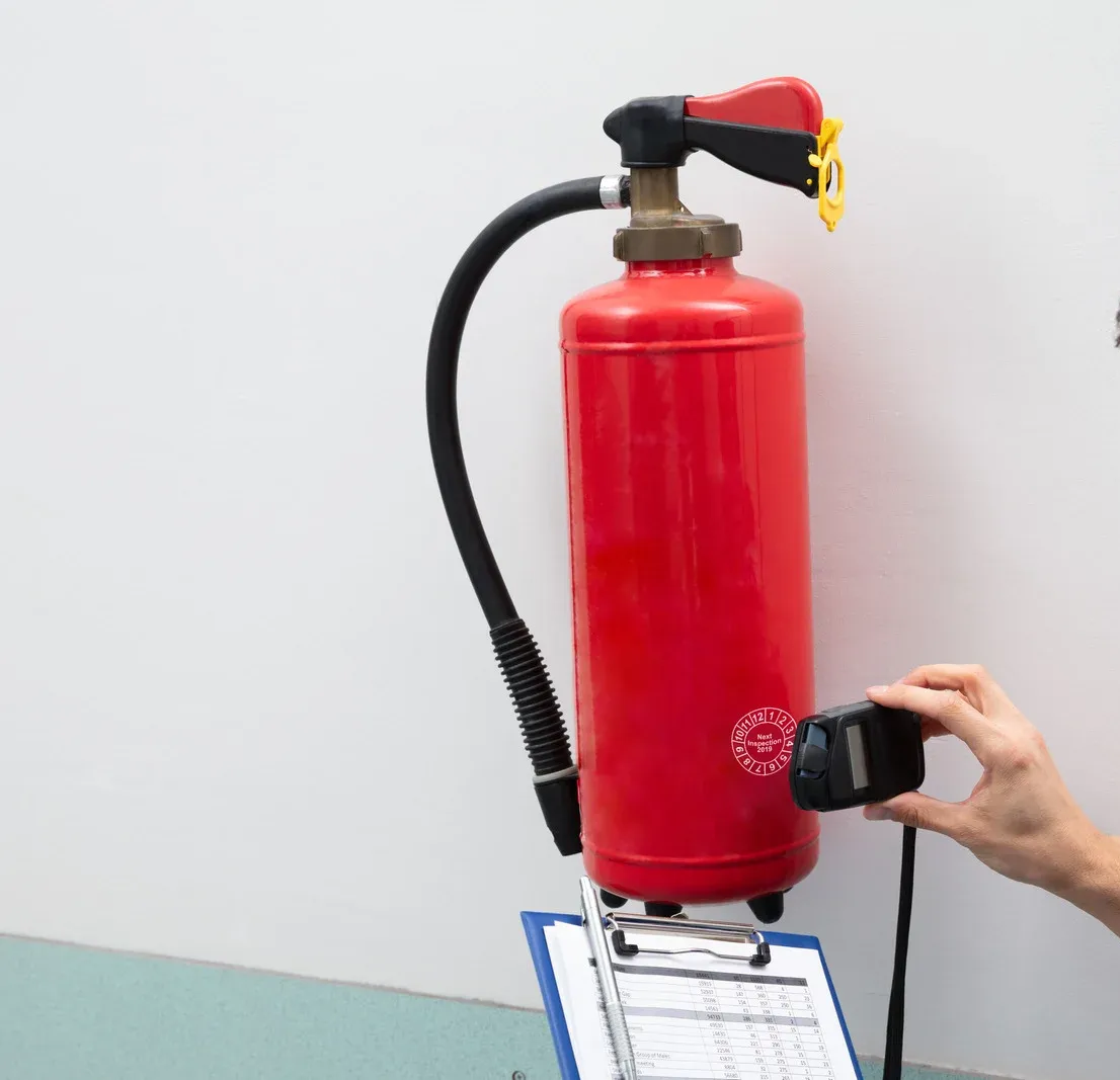 Four red fire extinguishers mounted on a concrete wall.