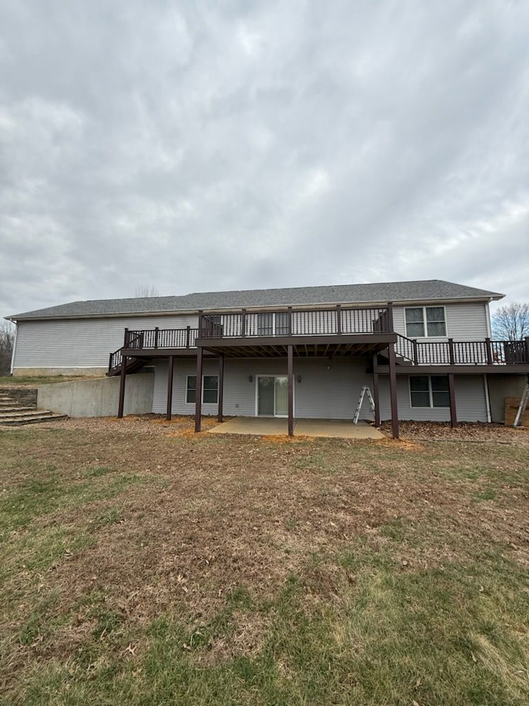 Brick house with a wooden accessibility ramp leading to the front entrance on a grassy lot.