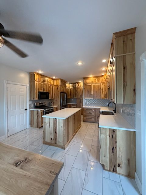 Bright, modern kitchen with wood cabinets, white tile floor, island, and stainless steel appliances