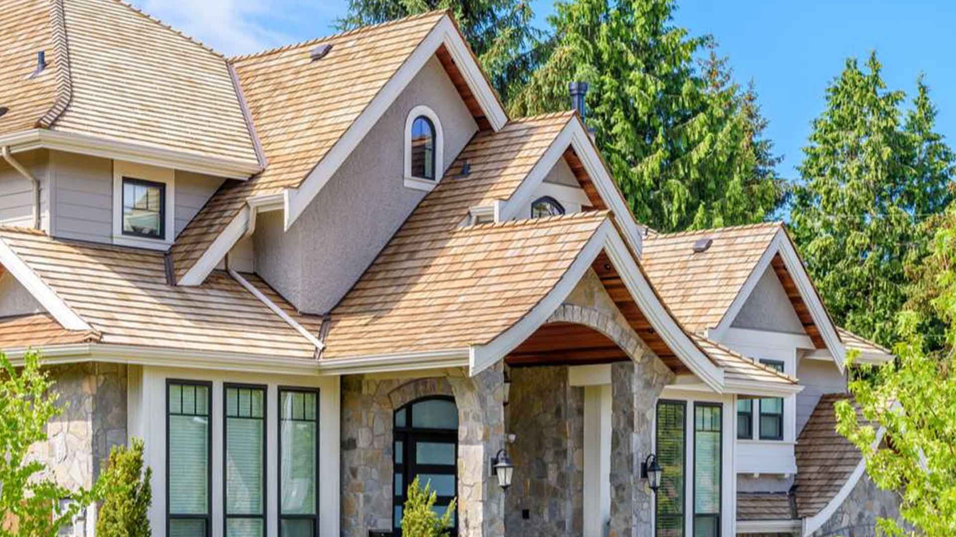 Brick house with a garage, front lawn, and clear blue sky