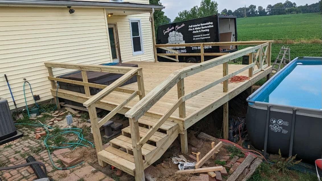 Wooden ramp and steps under construction beside a house and above an above-ground pool.