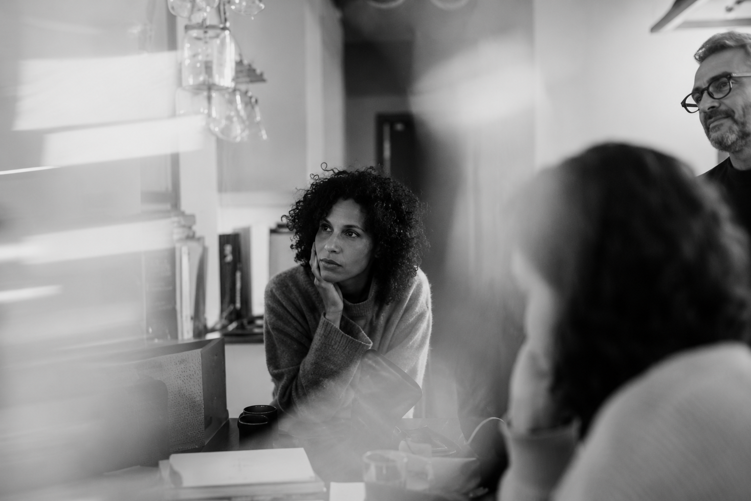 People in a meeting room, one person listening intently across a table