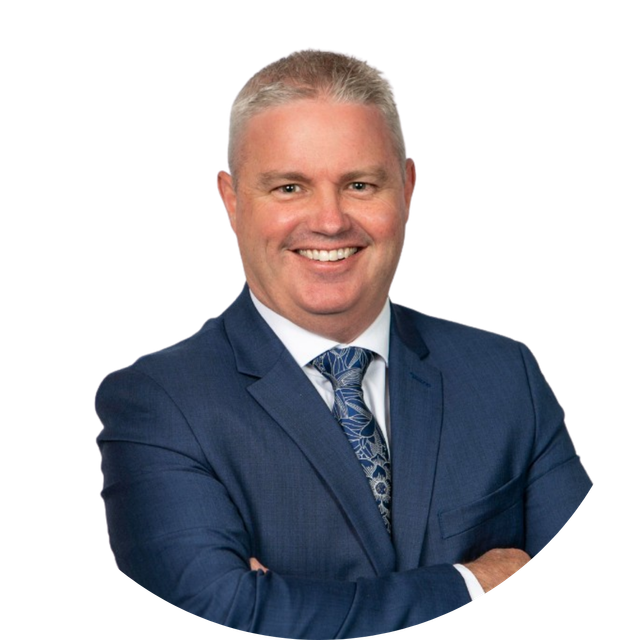 Smiling man in a navy suit with arms crossed on a white background