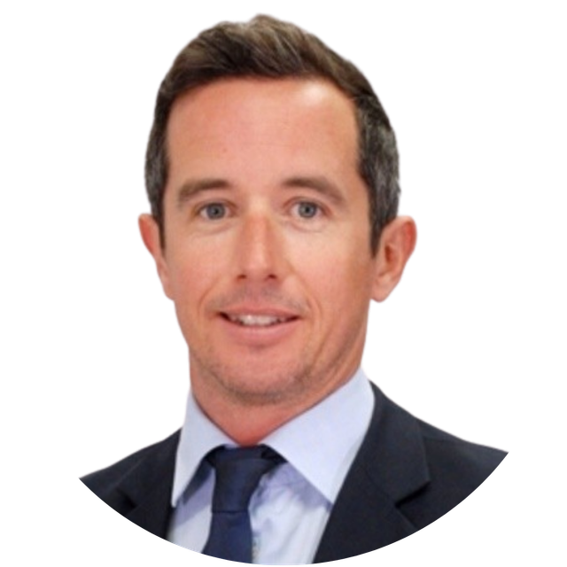 Headshot of a smiling man in a dark suit and blue tie on a white background