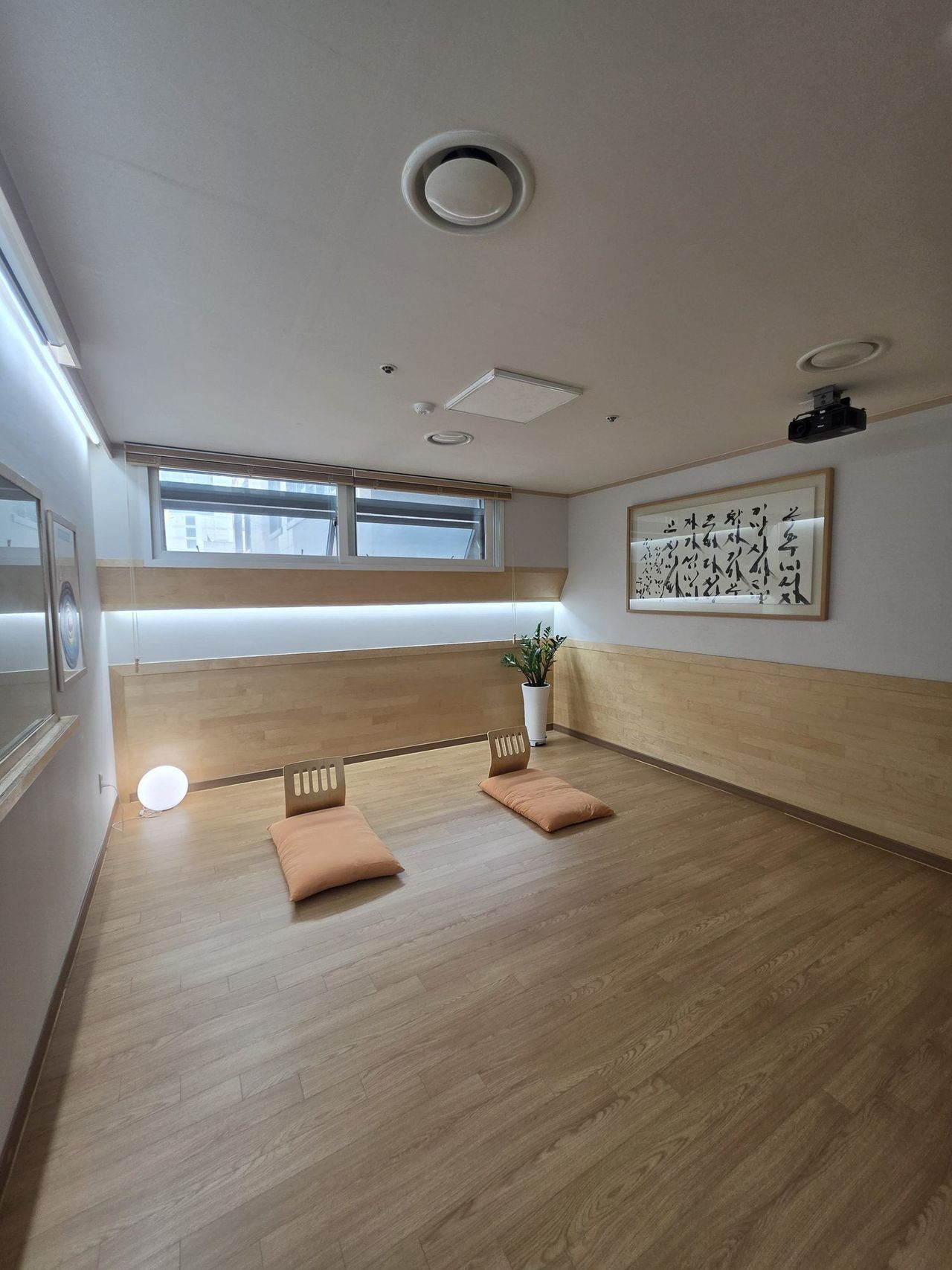 Meditation room at Maum Meditation Cheongdam, with floor cushions and calligraphy