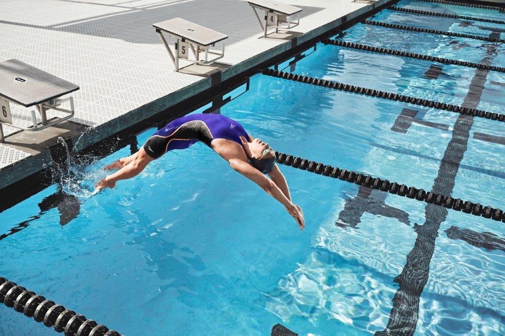 A woman is diving into a swimming pool.