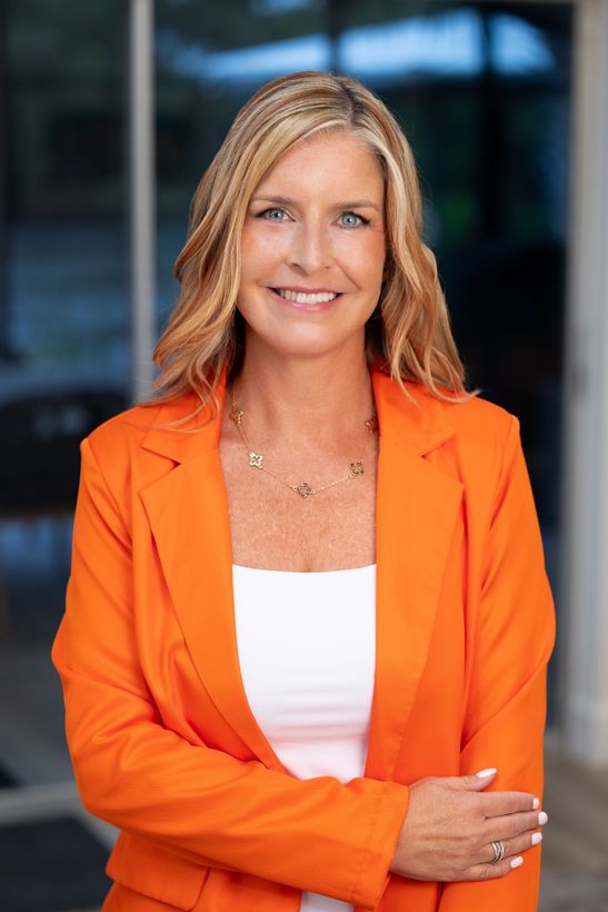 A woman is standing with her arm crossed.