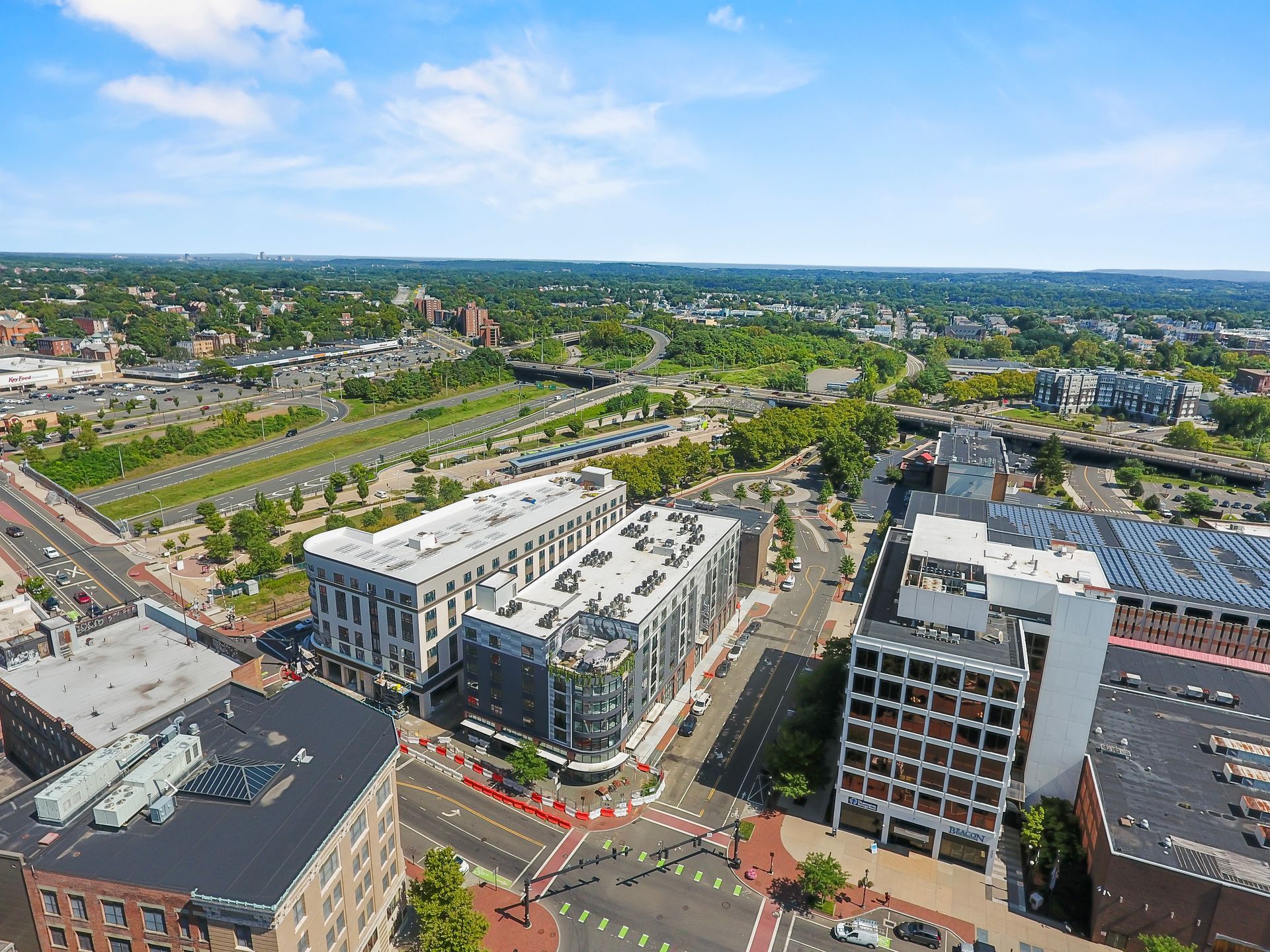 Aerial view of downtown buildings and surrounding landscape with roads and train tracks.