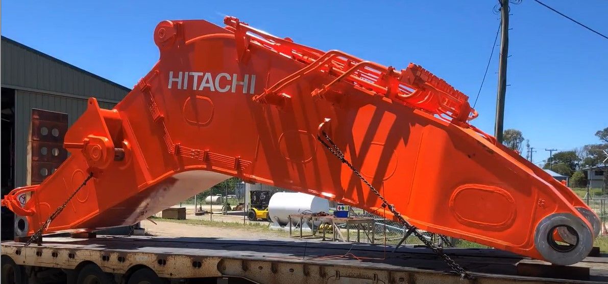 A Large Orange Excavator Arm Is Sitting On Top Of A Truck — ADR Engineering in Collinsville, QLD