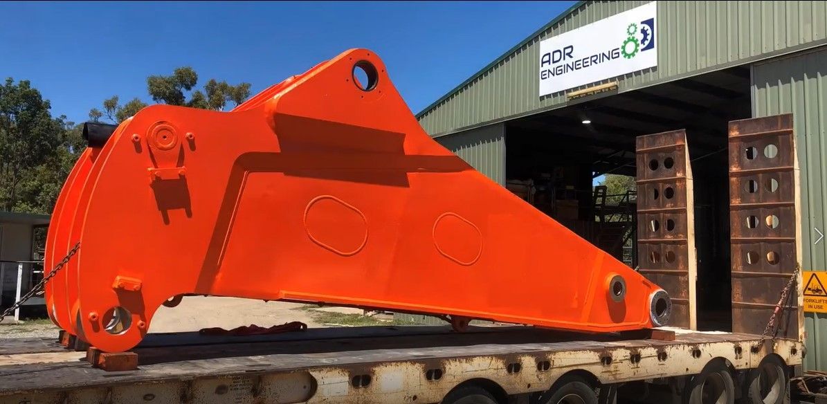 A Large Orange Object Is Sitting On Top Of A Trailer In Front Of A Building — ADR Engineering in Collinsville, QLD