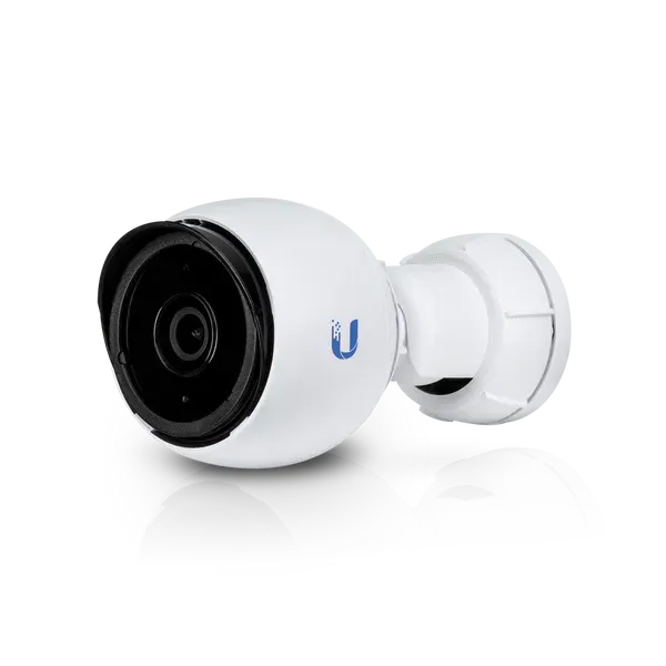 A white camera with a black lens is sitting on a white surface.