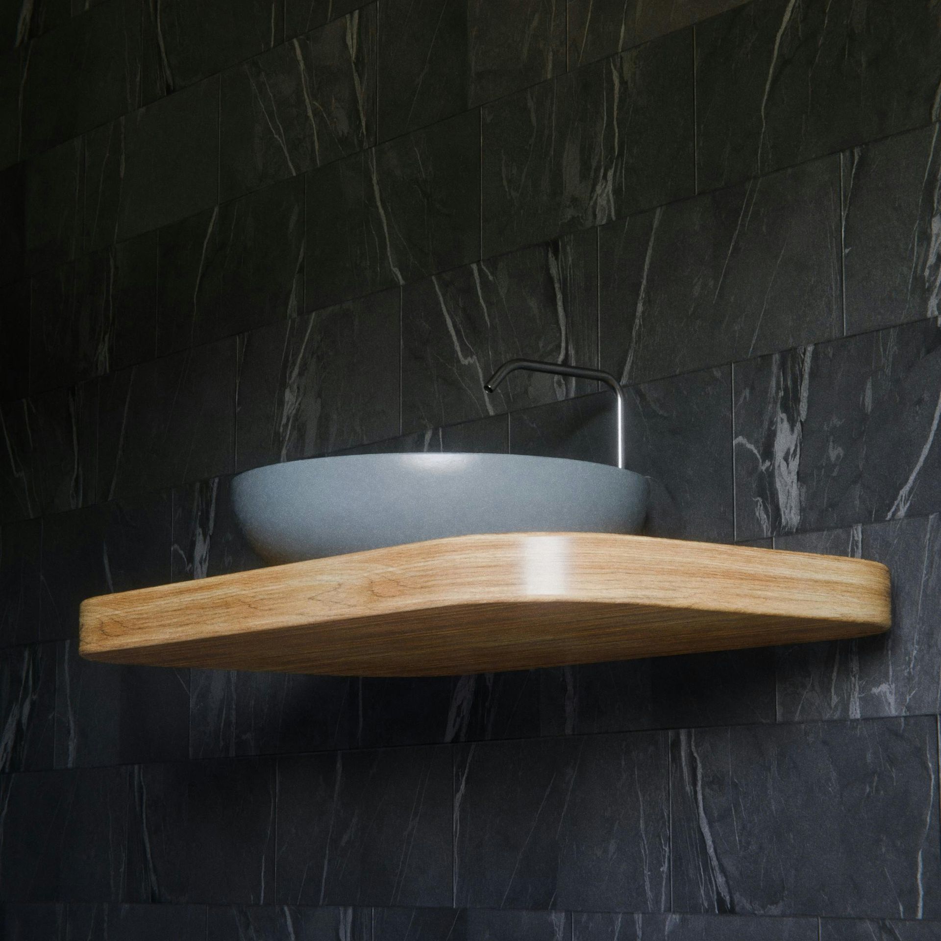 Gray vessel sink on a floating wood shelf against a dark stone-tile wall