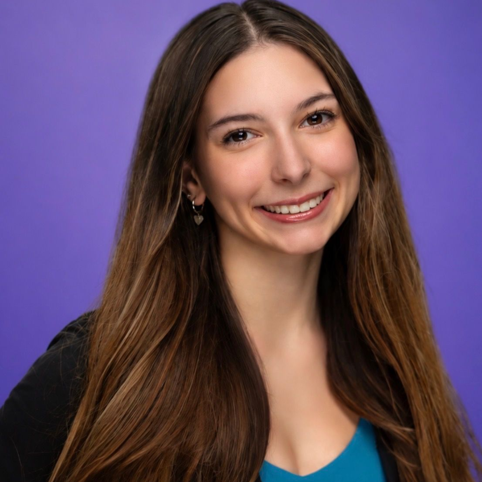 Smiling woman with long brown hair on a purple background