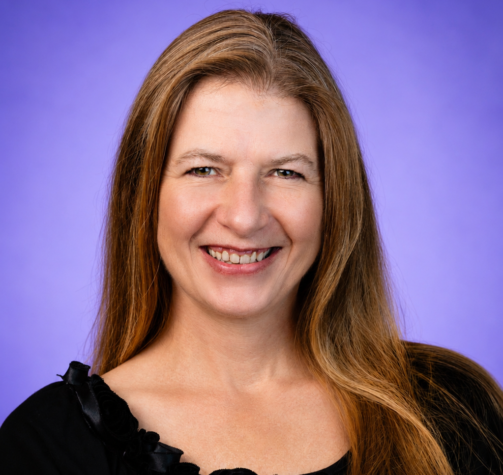 Smiling woman with long brown hair against a purple background