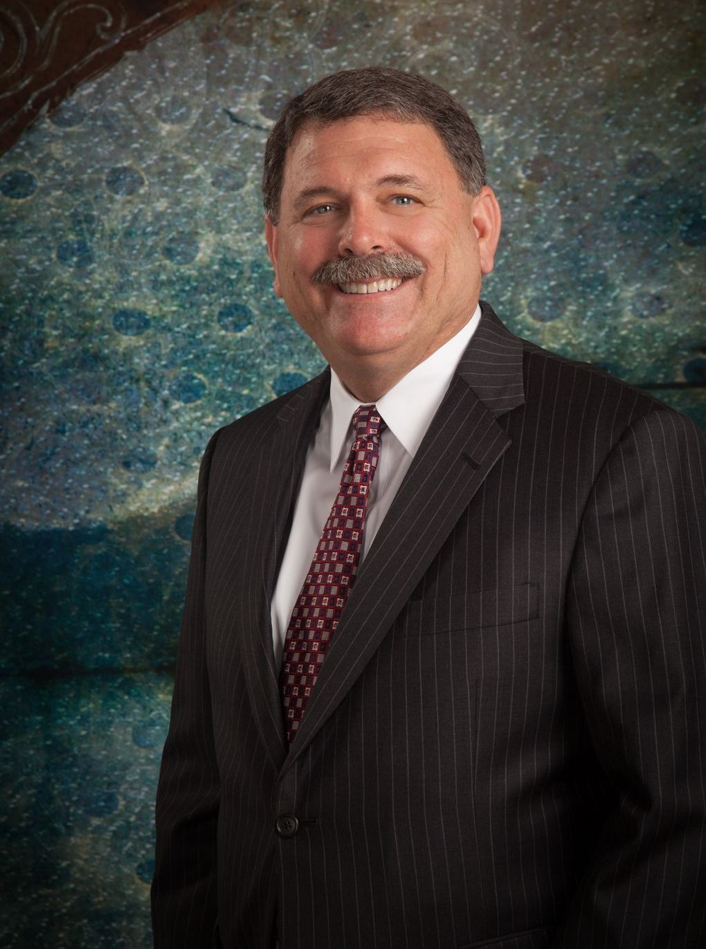 A man in a suit and tie is smiling for the camera.